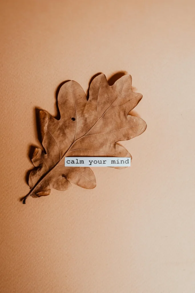 A golden brown gradient background and a leaf in the middle with text "calm your mind" a beautiful design wallpaper.